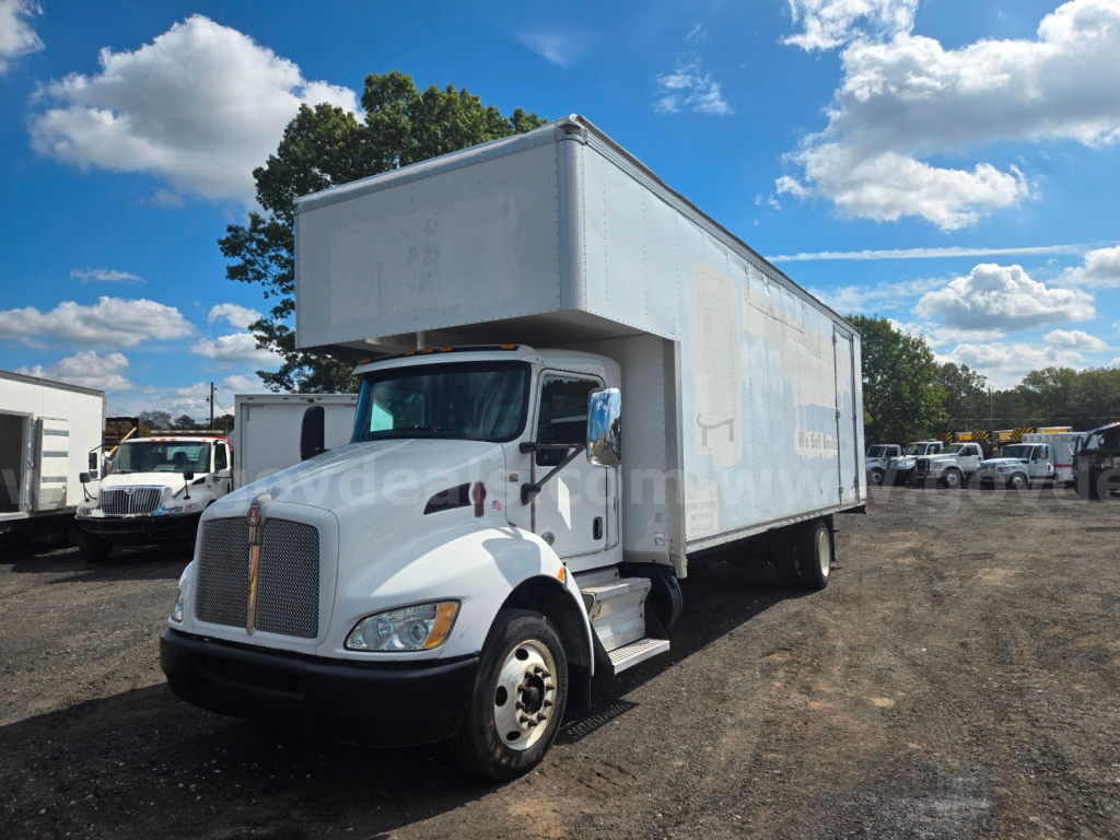 Kenworth box truck 2018, side view showing cargo box with cab in foreground and clear sky.
