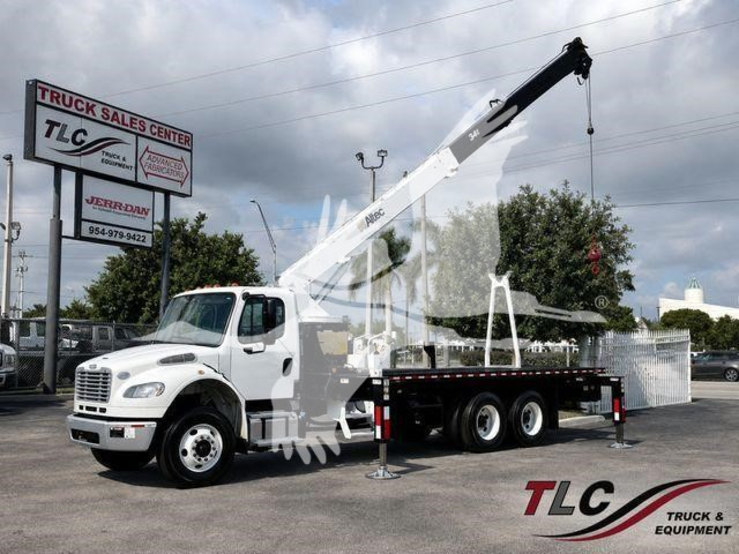 Altec Ac18-70B crane mounted on a white truck with outriggers deployed and crane arm extended in a yard.