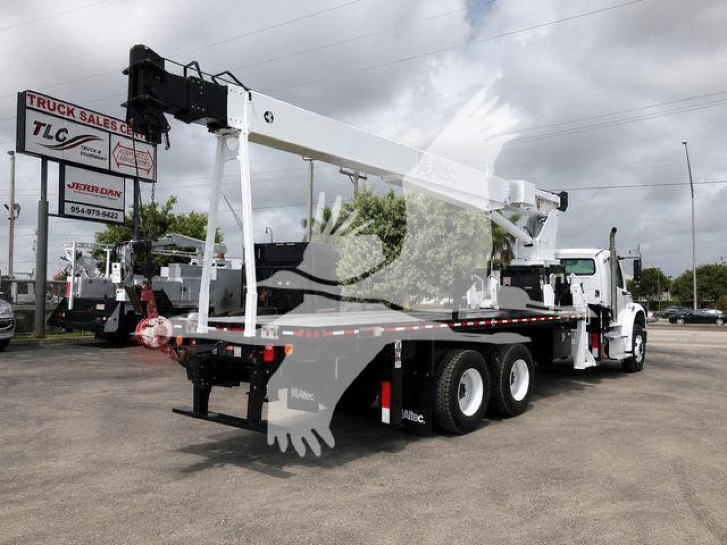 Altec AC18-70B crane mounted on a truck chassis with extended boom and stabilizers in a dealership lot.