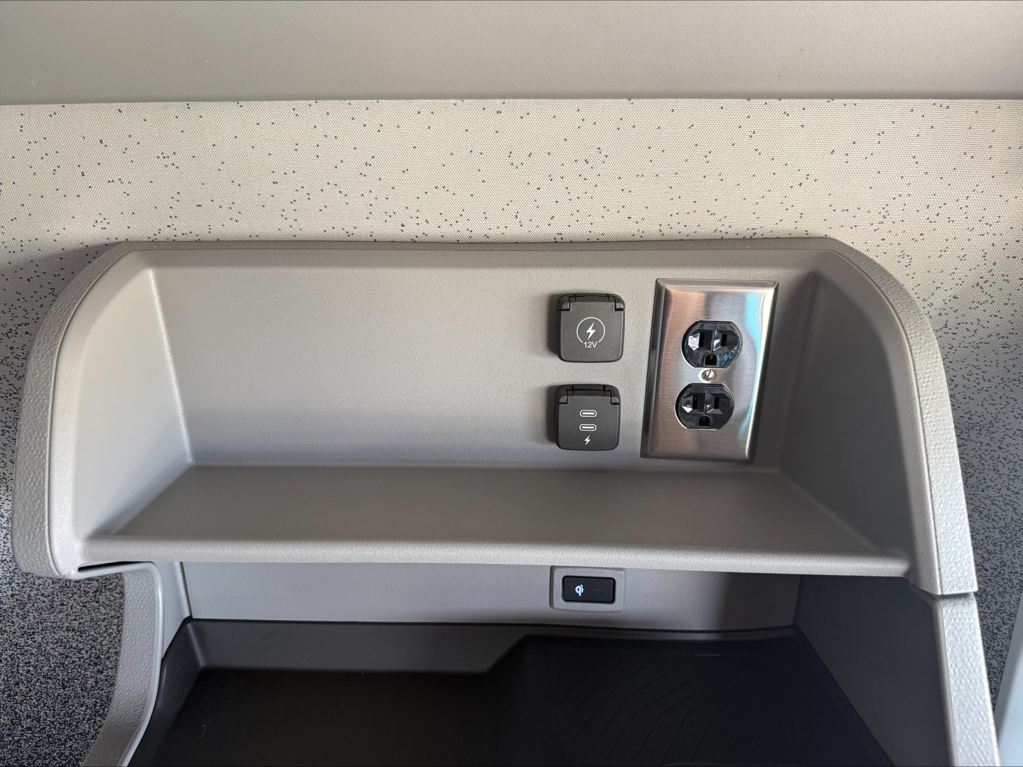 Truck cab interior showing power outlets and a USB-C/2x 120V socket panel in the dash area with a small storage shelf.