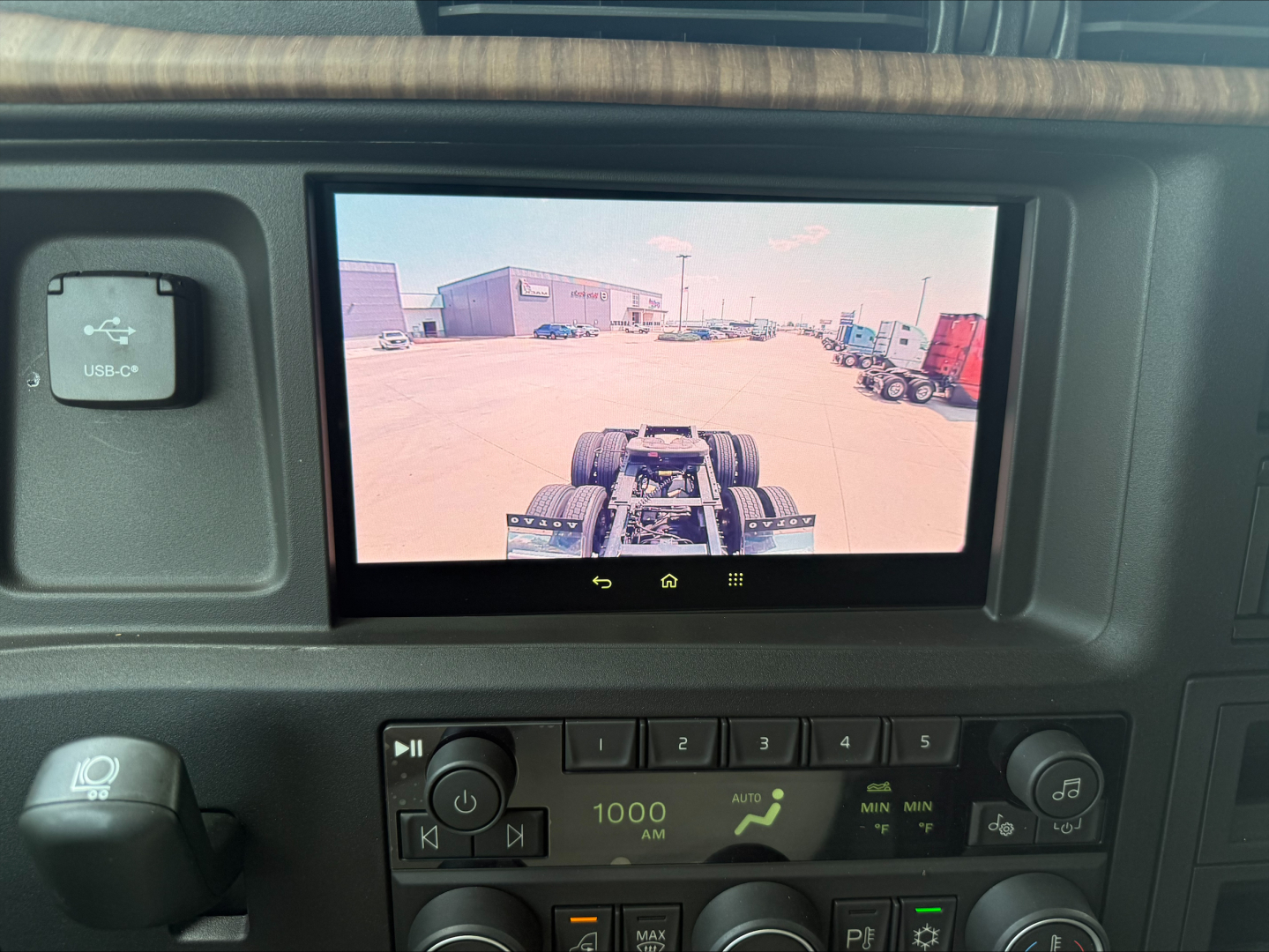 Volvo VNL64T860 dash display showing rear view camera screen with truck cab interior controls in view.