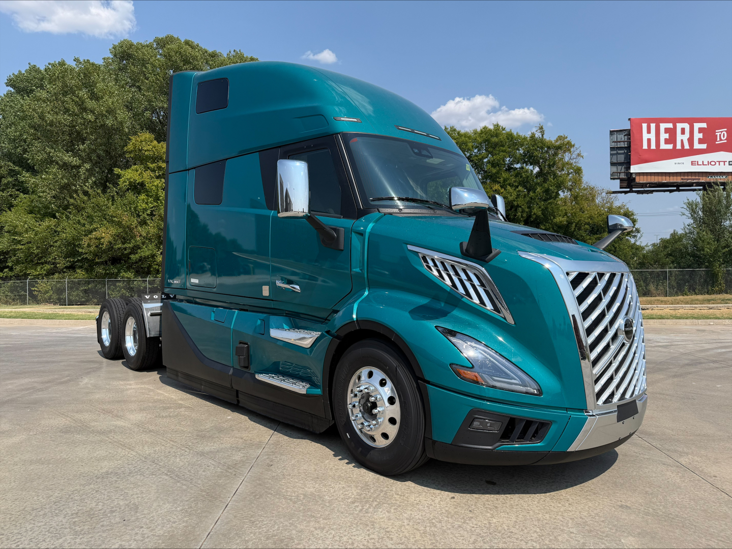 Volvo VNL64T860 truck in teal color showing front grille and side profile with sleeper cab.