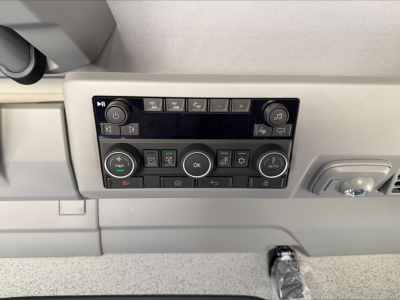 Control panel in Volvo VNL dashboard with multiple buttons and knobs, including climate and media controls, visible overhead console area.
