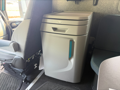 Truck cab interior showing center console with storage drawer and vertical turquoise accents, near seating area and floor mat.