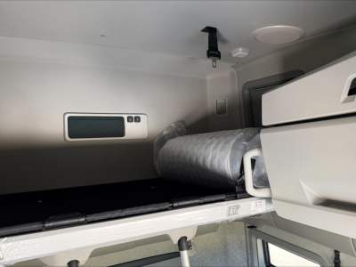 Volvo VNL64T860 sleeper cab interior showing bunk area storage and folded mattress in cabin.