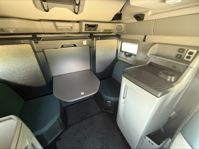 Volvo VNL64T860 sleeper cab interior showing table and storage compartments with gray upholstery and control panel
