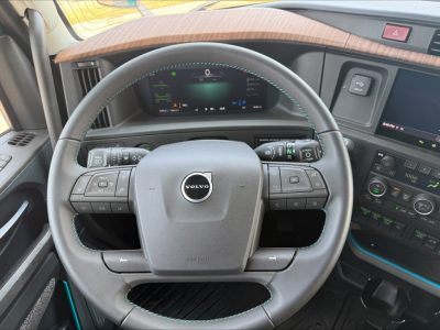 Volvo VNL64T860 truck cab interior showing steering wheel with Volvo emblem and digital dashboard display.