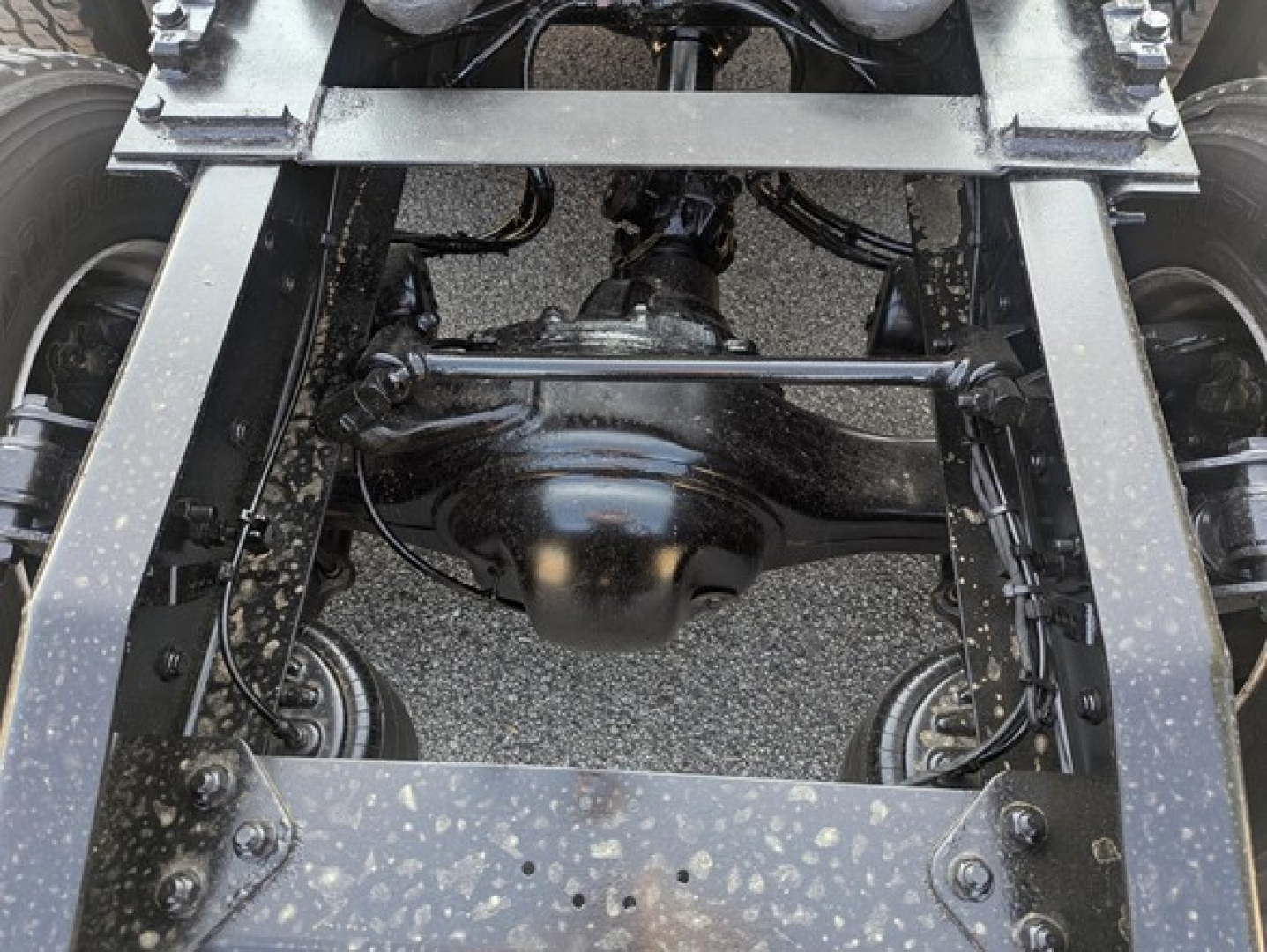 Rear-view of Freightliner Cascadia chassis showing drive axle assembly, suspension, and frame rails.