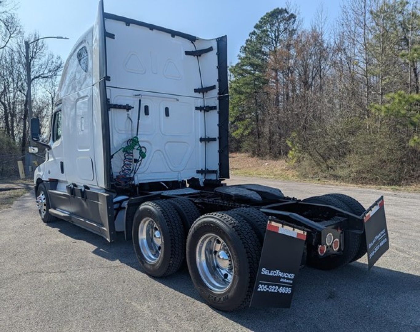 Truck chassis rear and cab of a Freightliner Cascadia 126 truck, dual rear axles, white cab, fifth wheel area visible.