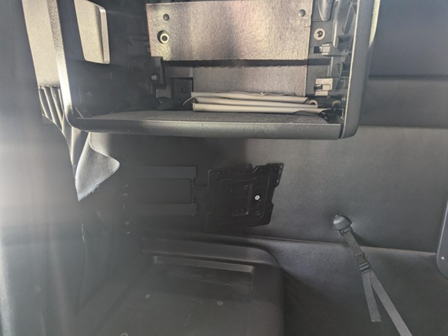 Interior cab area of a Freightliner Cascadia showing a dashboard slot area and blank compartment with some wiring and plastic trim.