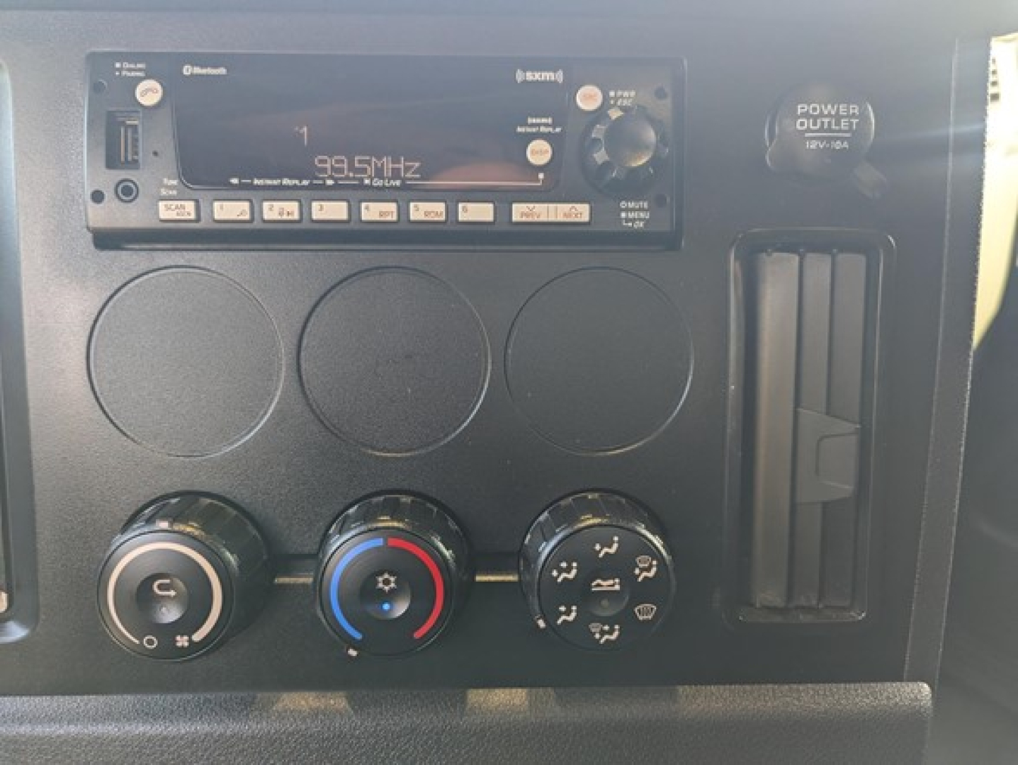 Trucks dash panel showing FM radio unit and climate control knobs in Freightliner Cascadia interior.