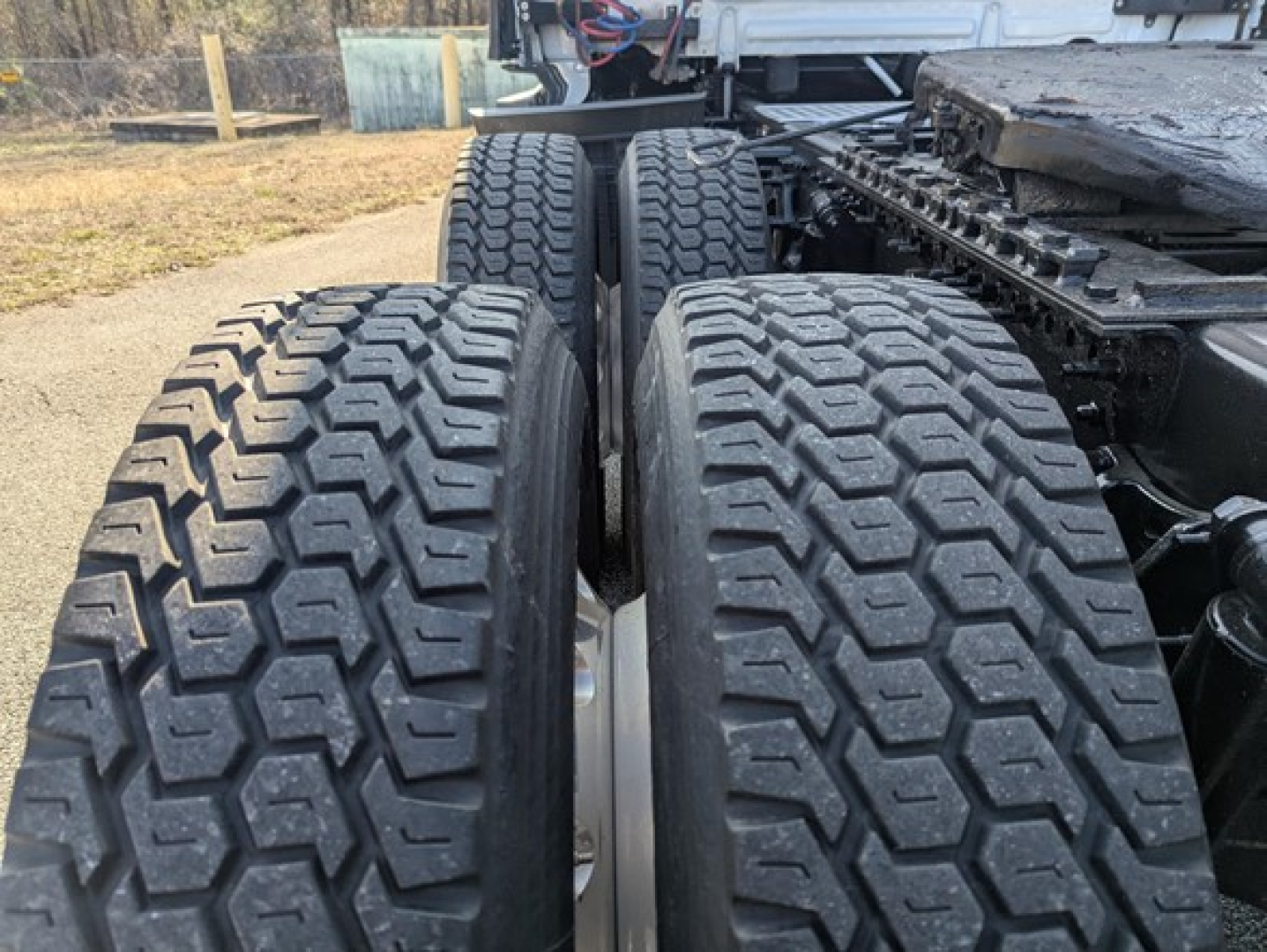 Freightliner Cascadia tractor rear dual tires and fifth wheel area showing tread pattern and suspension components.