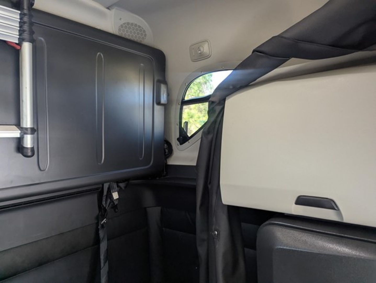 Freightliner Cascadia 126 sleeper cab interior showing side window and bunk area.