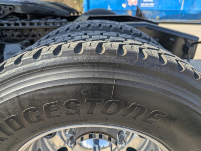 Tire close-up on a Freightliner Cascadia truck showing Bridgestone tire tread and sidewall text.