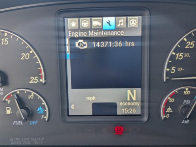 Truck instrument cluster display showing Engine Maintenance icon and 14371:36 hrs while gear indicator shows N for neutral; speed/eco gauges on sides.
