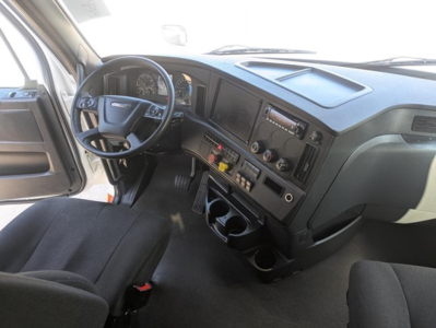 Freightliner Cascadia 126 cab interior showing dashboard with steering wheel, instrument cluster, center console, gear shifter, and cup holders.