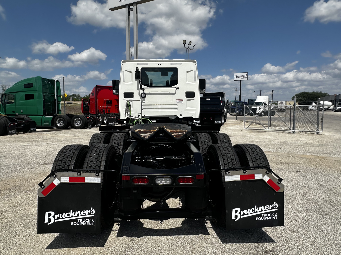 Mack AN64T tractor rear view showing dual rear axles and mud flaps with Bruckner's Truck Equipment branding.
