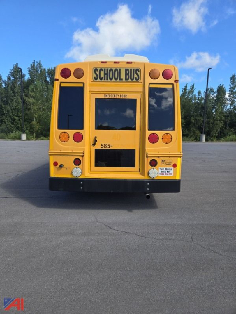 Rear view of a yellow 2018 Chevrolet Express G4500 mini school bus with school bus signage, emergency door, and rear lights.