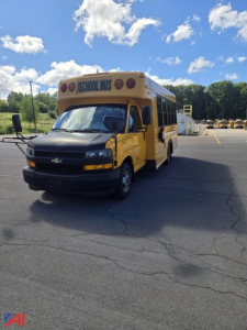 2018 Chevrolet Express G4500 mini school bus front-left view showing yellow body and 'SCHOOL BUS' sign on roof
