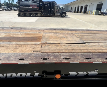 Landoll 455 trailer bed with wooden planks and steel edge shown from rear side, industrial lot in background