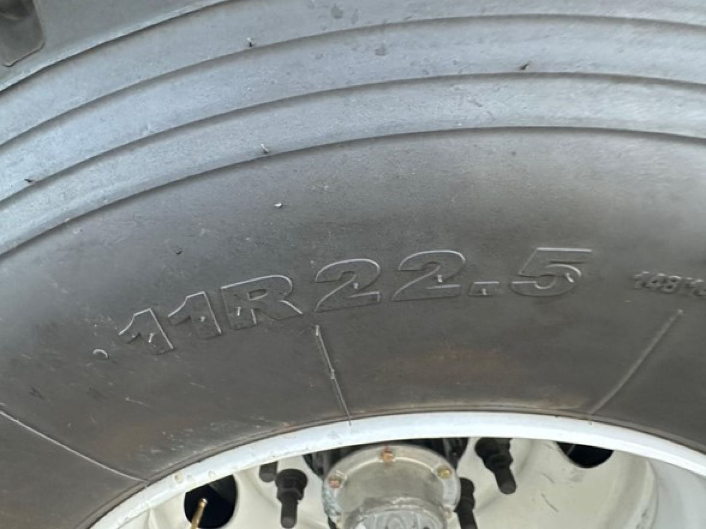 Truck tire sidewall with embossed size 11R22.5 on the outer bead.