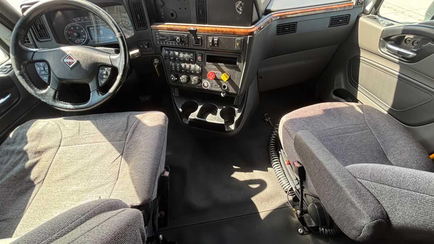 Truck cab interior showing steering wheel, dashboard, and two front seats in a 2022 International LT625.