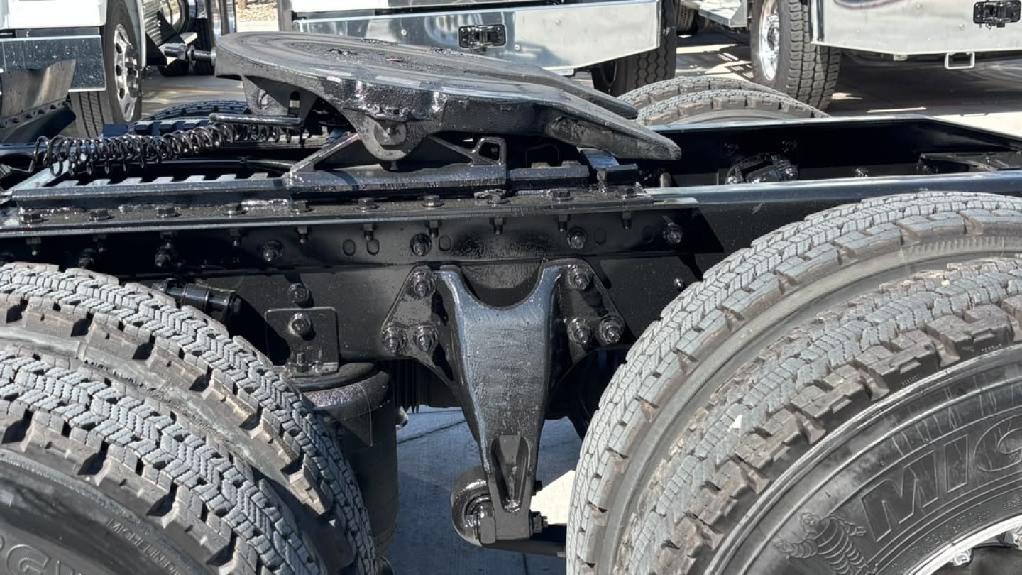 Truck chassis center view showing suspension and dual rear axles with tires and frame