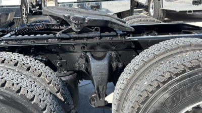 Truck chassis center view showing suspension and dual rear axles with tires and frame