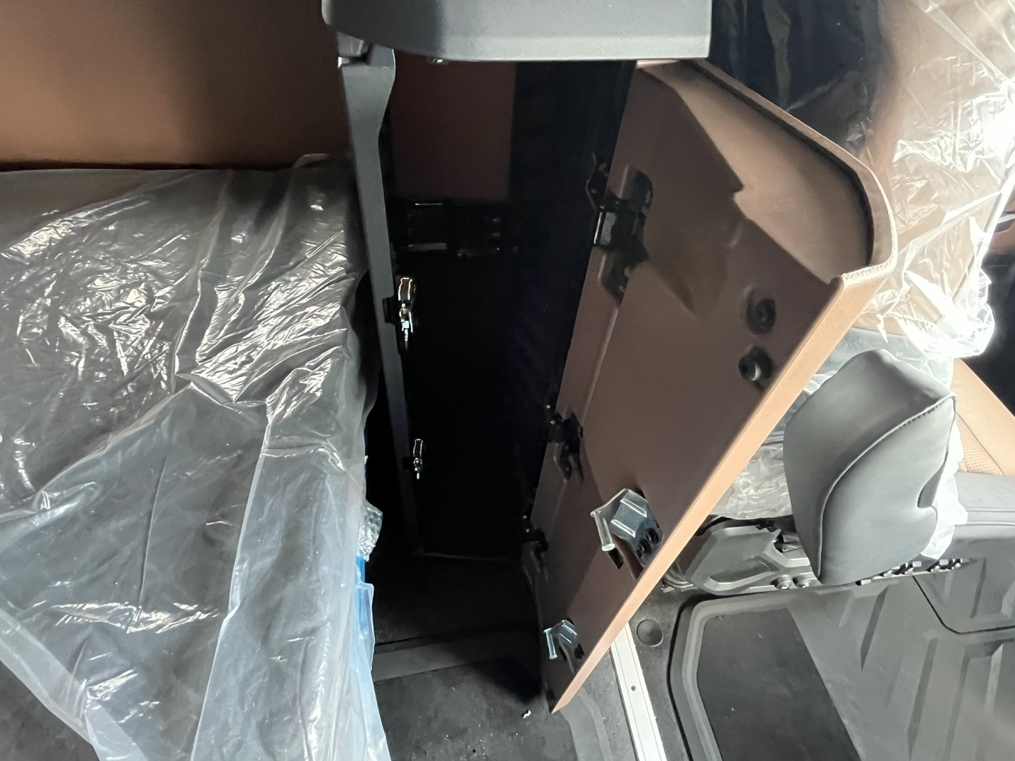 Cab interior of a Mack AN64T64 sleeper showing an open cabinet with a door, latches, and storage space.
