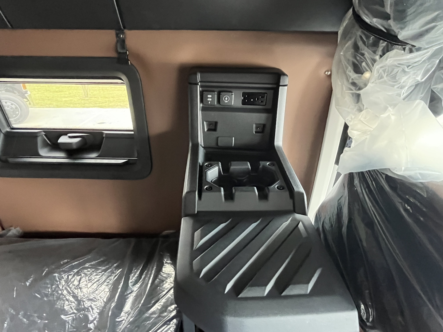 Interior view of a Mack AN64T64 truck cab showing a center console with cupholders and control panel.
