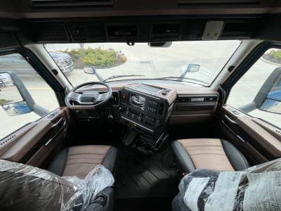 Truck cabin interior of a 2027 Mack AN64T64 conventional sleeper showing the steering wheel, dashboard, and front seats.
