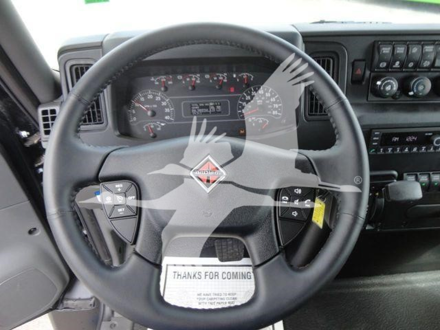 Steering wheel and dashboard of a 2027 International MV truck showing instrument cluster and controls.