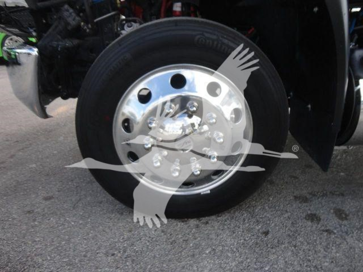 Truck wheel close-up showing polished aluminum hub and black tire on MV series International truck.