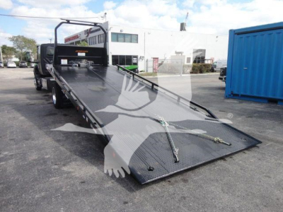 Tow truck rollback deck showing flatbed with chrome railing and ramp extending from truck bed.
