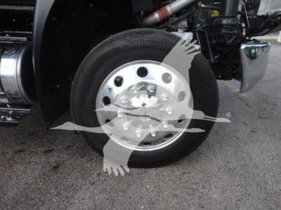 Truck wheel and front tire assembly with shiny steel rim and hub, visible label text on tire sidewall.