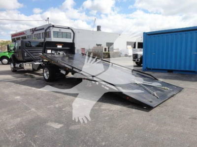 Truck with a hydraulic rollback bed extended, International MV model, stock number J47181FM, in a lot