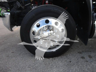 Truck wheel close-up showing polished aluminum hub and black tire on MV series International truck.