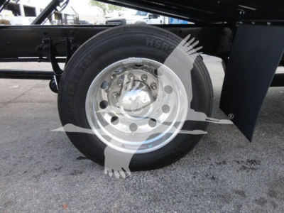 Wheel hub and tire of a truck trailer showing hub cap and lug nuts with discernible text on tire.