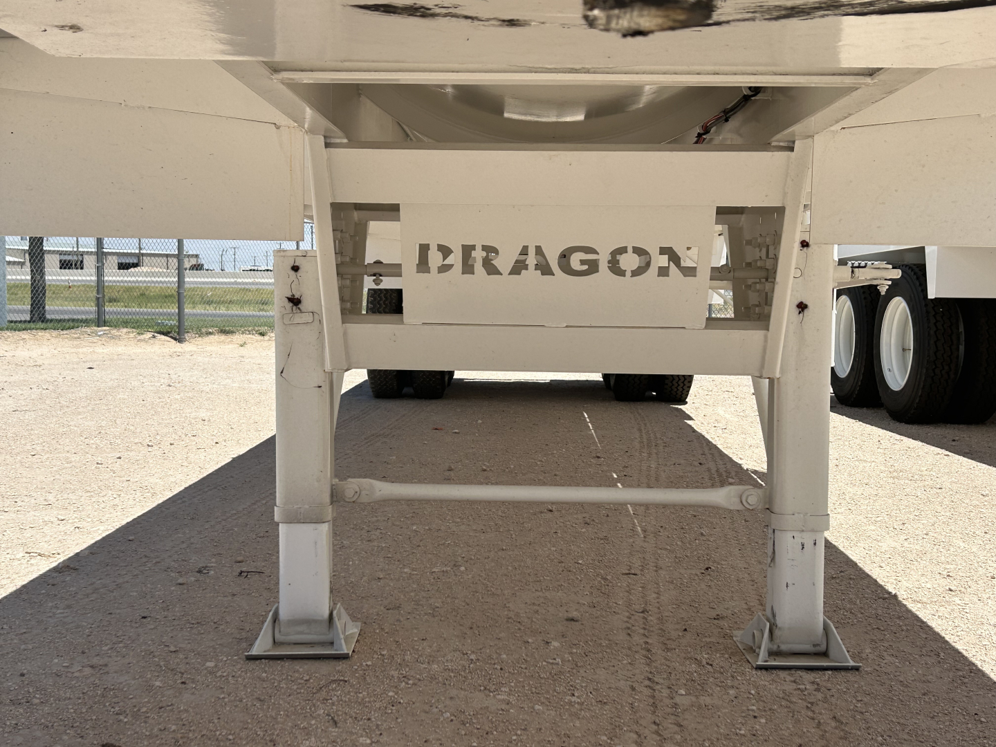 Dragon trailer landing gear showing DRAGON cutout branding between supports.