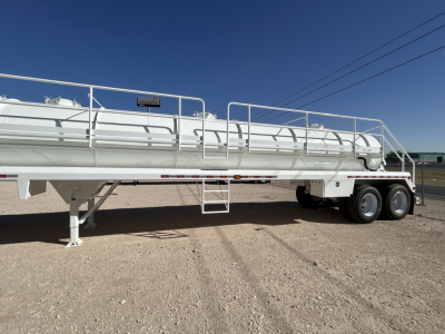 Trailer side view showing white Dragon 130BBL vacuum trailer with ladders, rails, and dual rear axles.