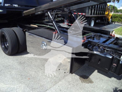 Ford F-600 rollback truck chassis side showing fuel cap and toolbox with visible undercarriage components.