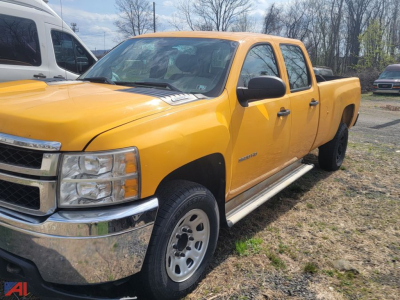 Chevrolet Silverado 3500HD crew cab pickup truck in yellow parked on a lot with other vehicles visible