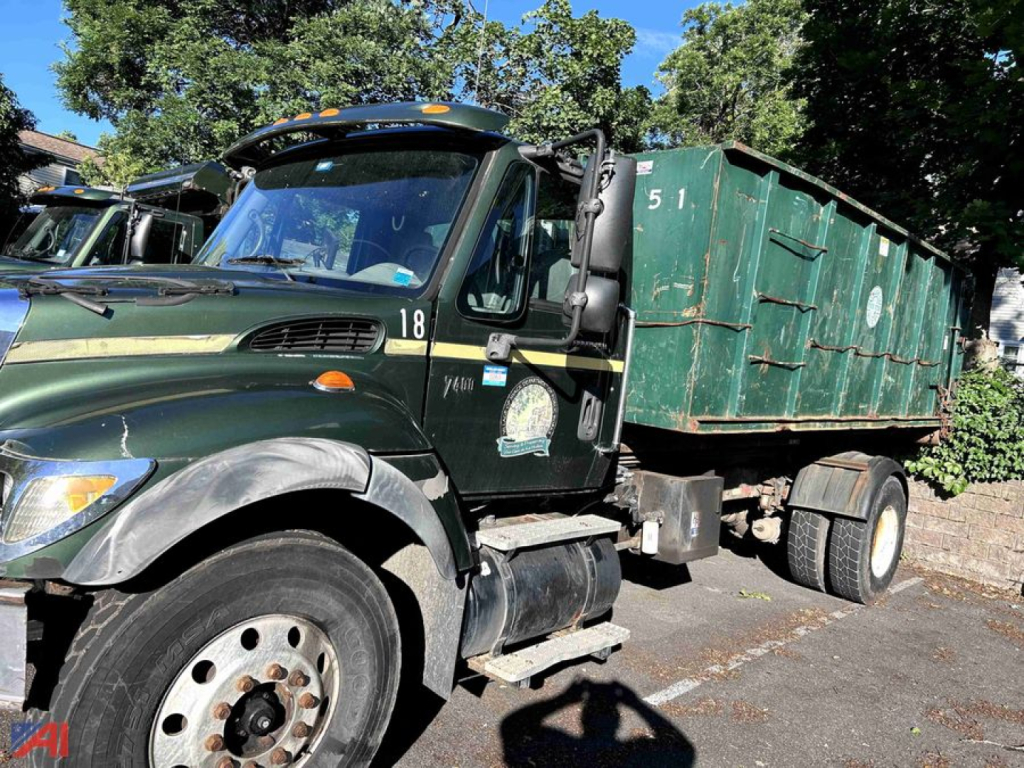 2005 International WorkStar 7400 dump truck in dark green with a green container body, side view showing cab details and hydraulic dump bed.