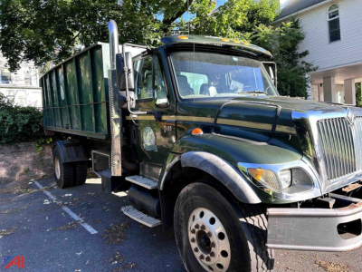 Dump truck showing International WorkStar 7400 with green cab and dump bed.