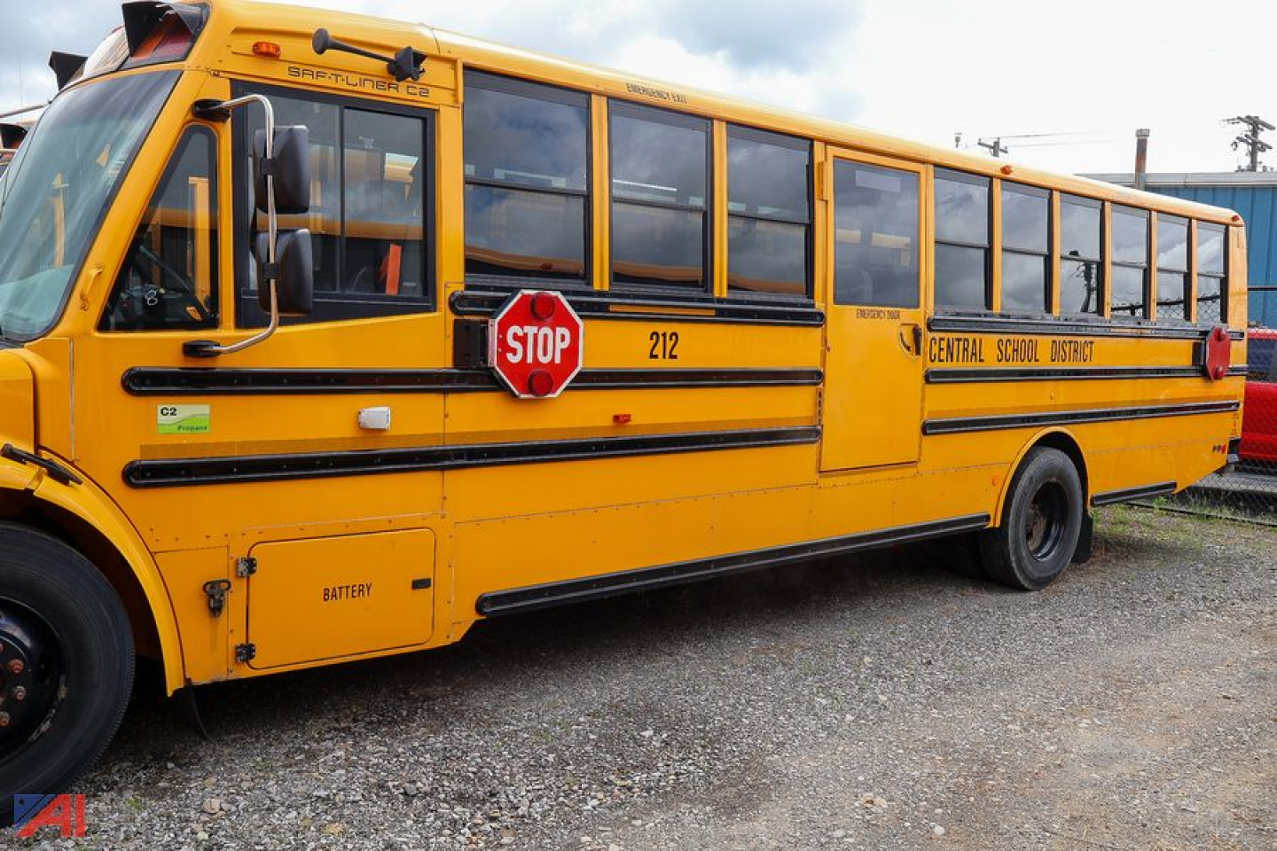 School bus showing yellow Freightliner C2 Saf-T-Liner with stop sign, side lettering Central School District and battery compartment, visible number 212
