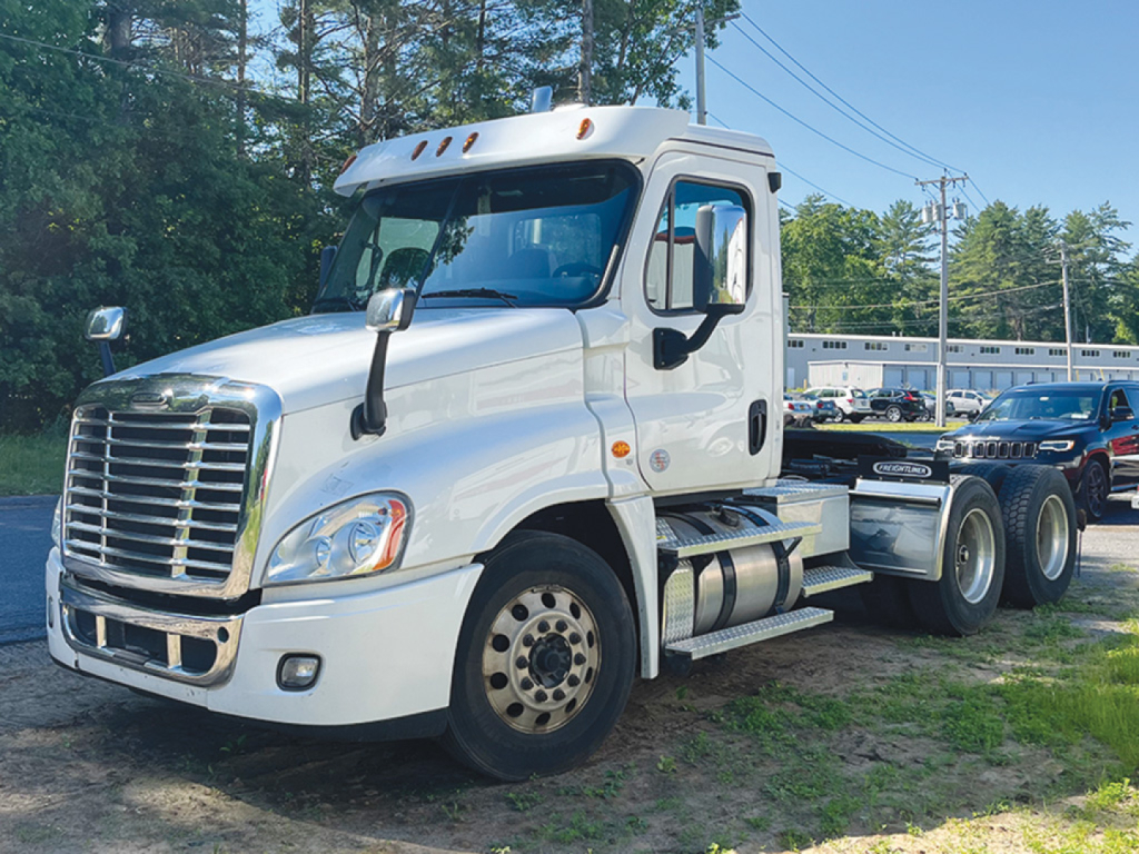 Freightliner Cascadia125 daycab tractor truck side view showing front grille and cab with dual fuel tanks.