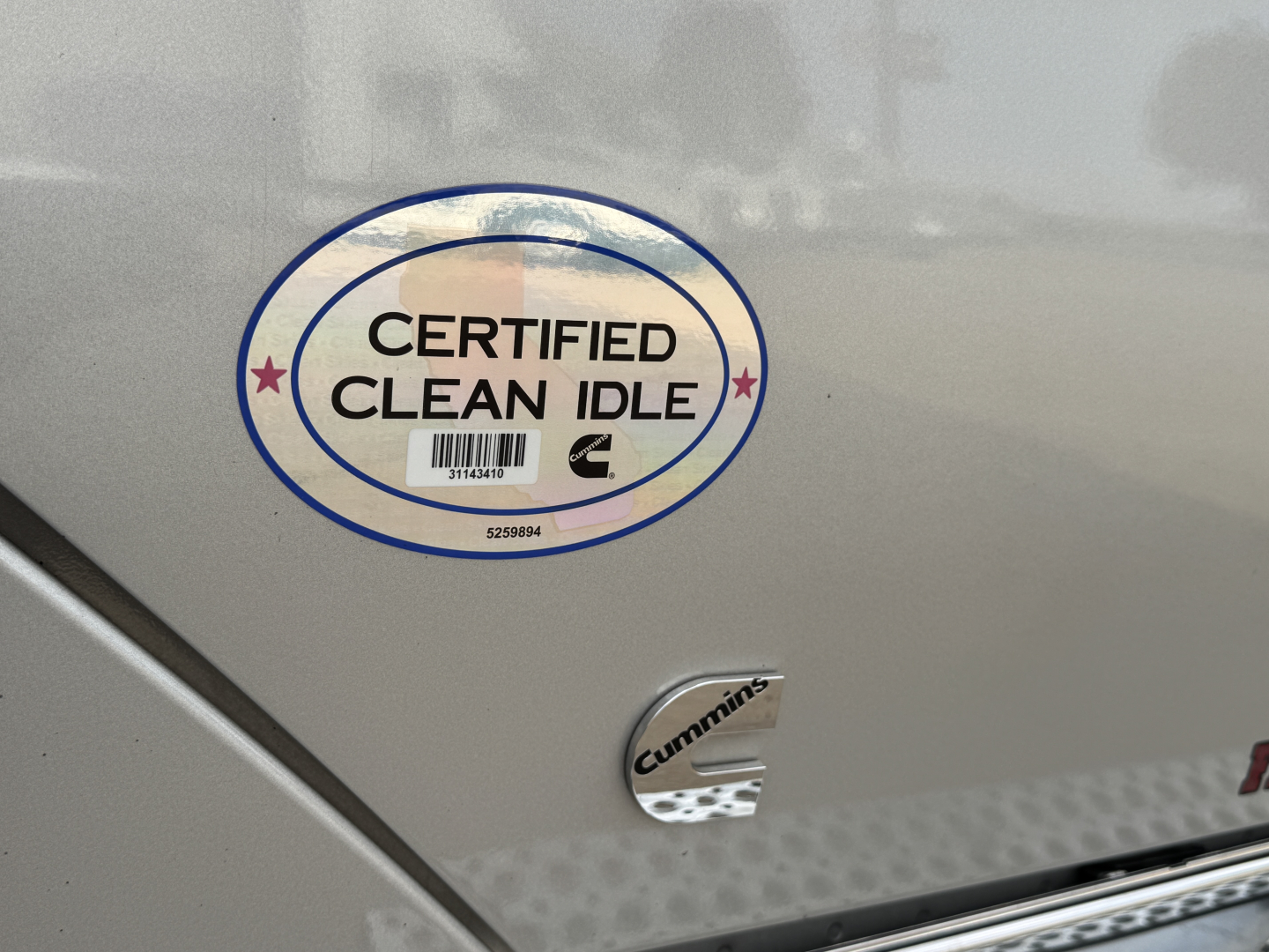 Truck exterior with Certified Clean Idle sticker and Cummins badge on the side.