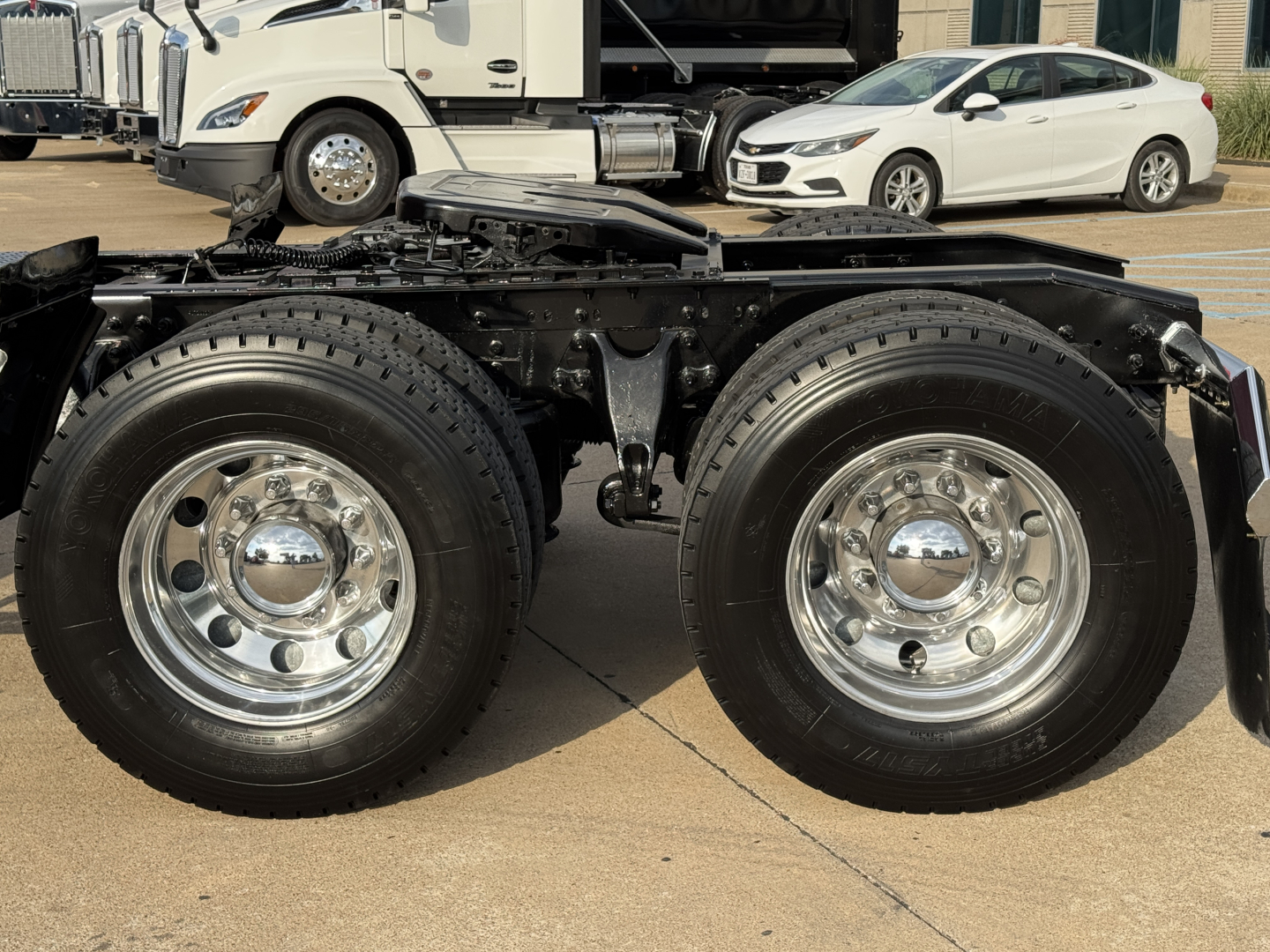 Dual rear wheels on a truck chassis showing polished chrome rims and black suspension components.