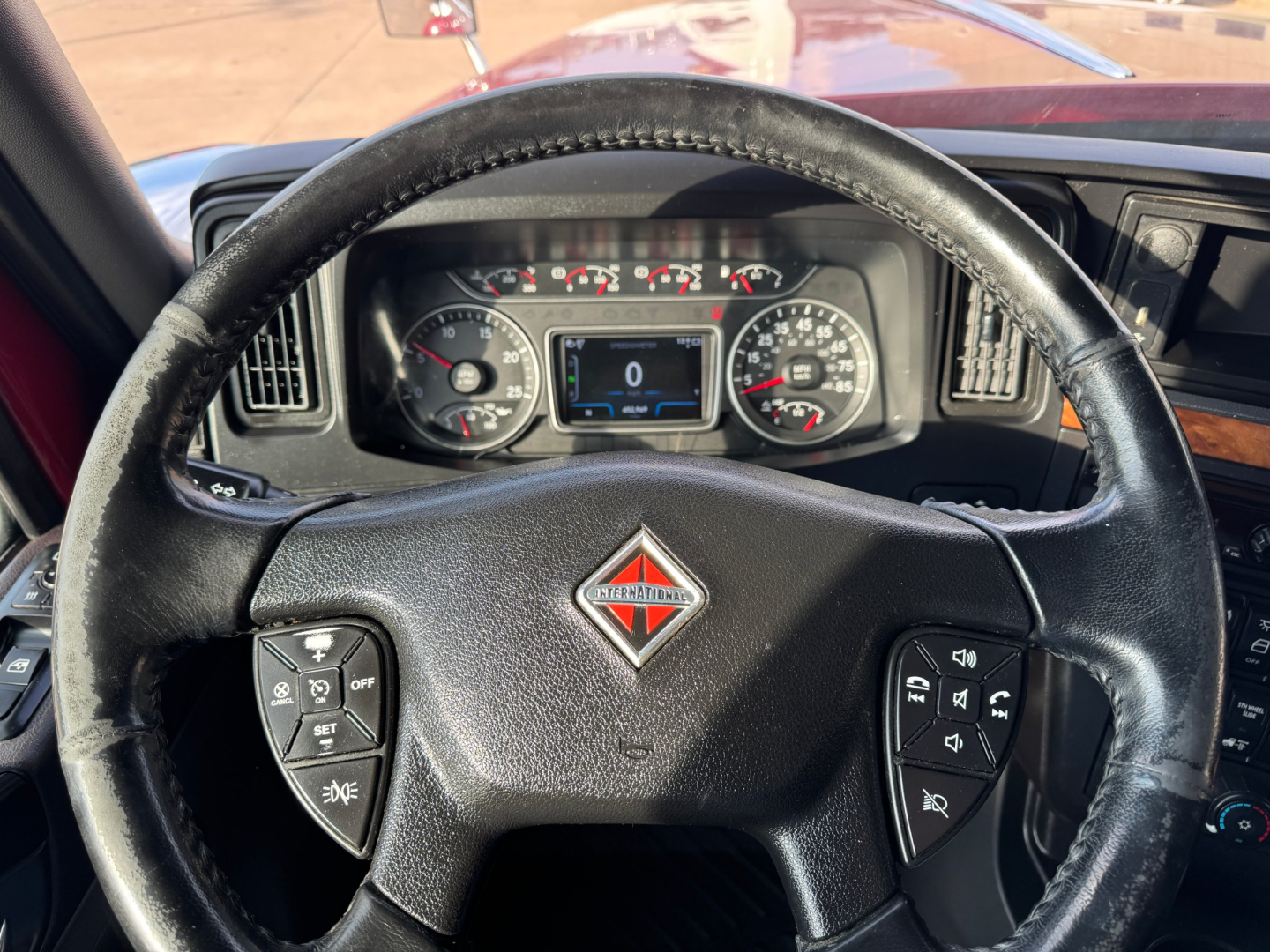 Steering wheel and instrument cluster of a 2021 International Lonestar truck interior showing gauges and center display.