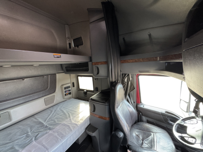 Interior sleeper cab of a used 2021 International Lonestar showing bunk bed area and driver's seat.
